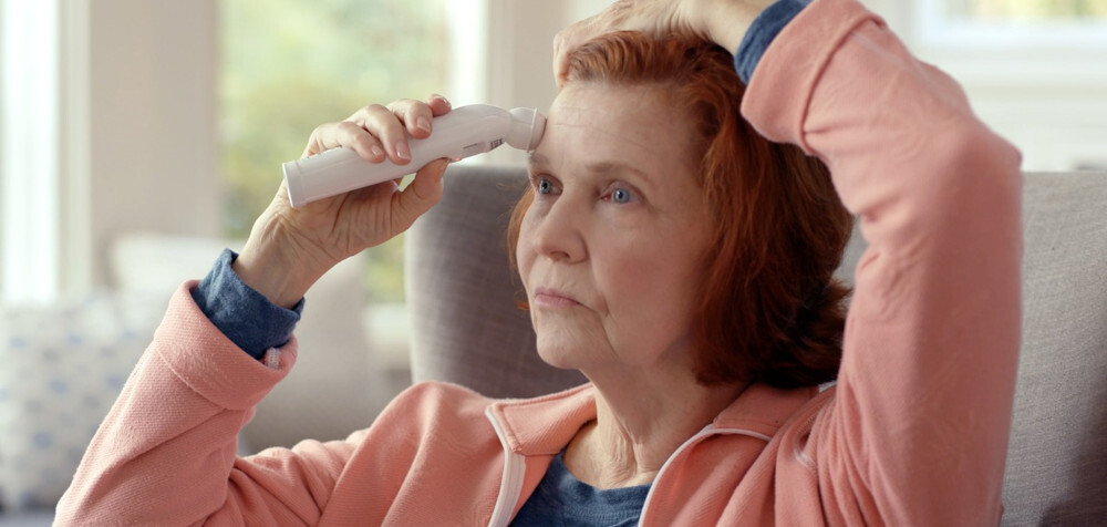 starsza kobieta mierząca sobie temperaturę